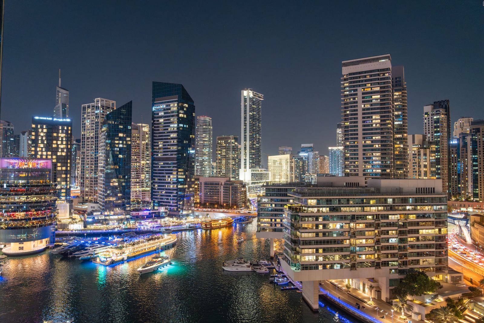 Dinner afloat as the Marina’s towers light up around you.
