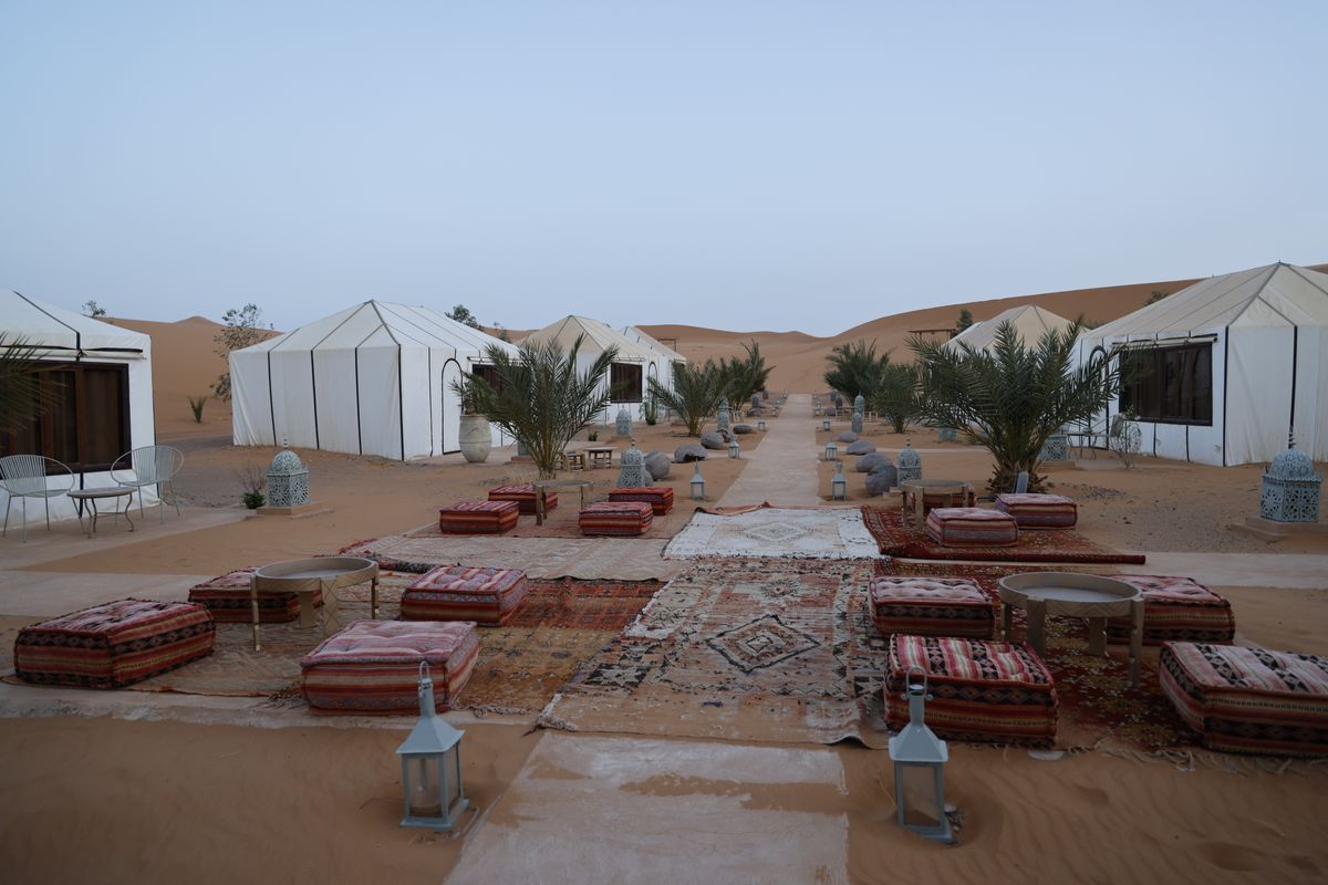 The camp’s tents and cushions laid out among the dunes