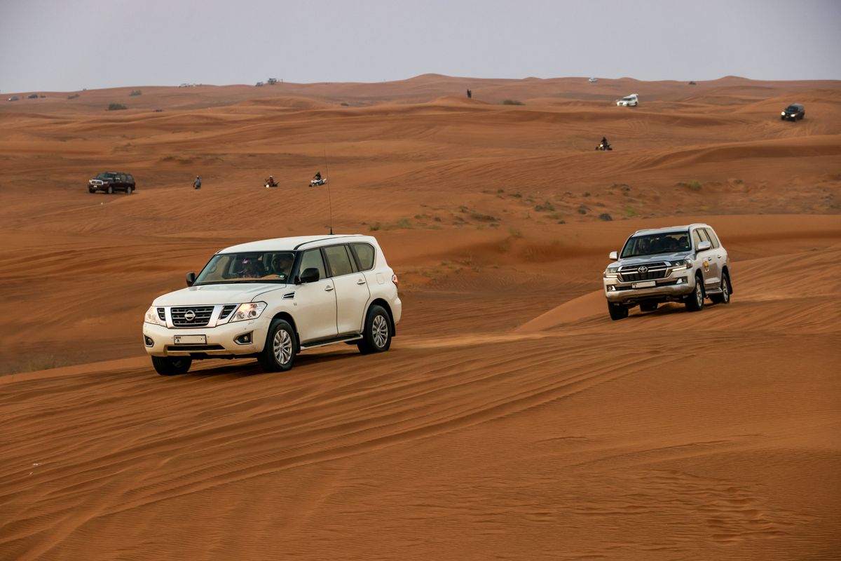 The white 4×4 convoy lined up on the sand before the drive