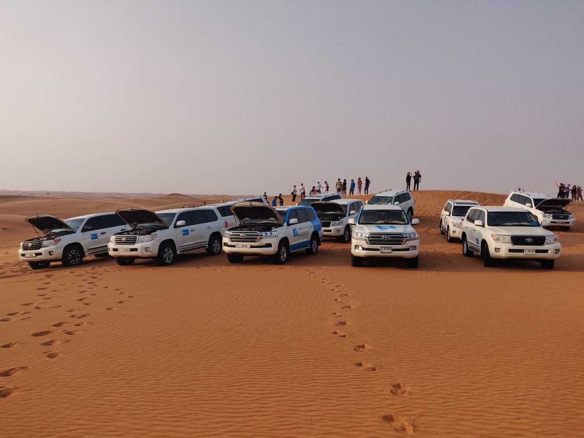 Friends beside their 4×4 watching the desert sunset
