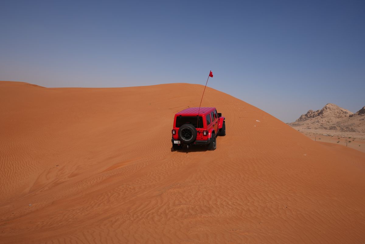 The 4×4 pausing on morning sand under a clear sky