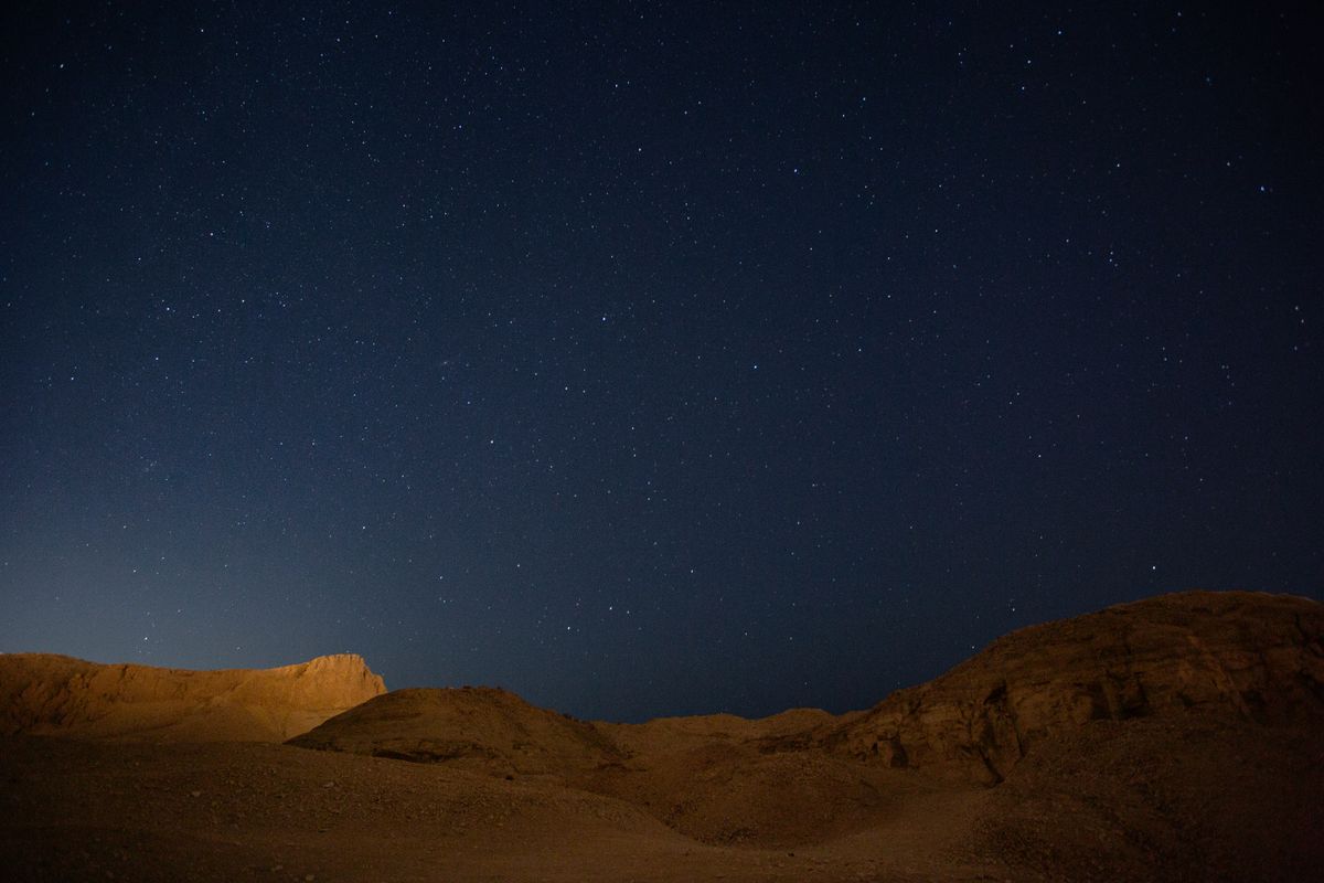 The desert hills going silver under the starlight