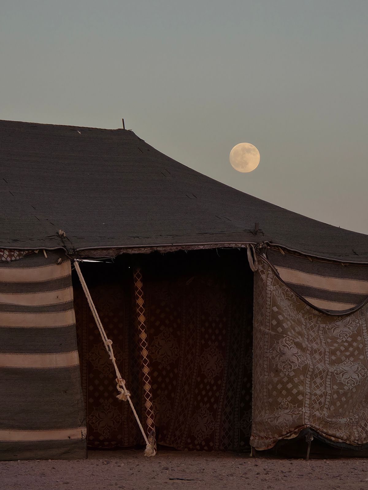 The tent under a full moon in the desert night