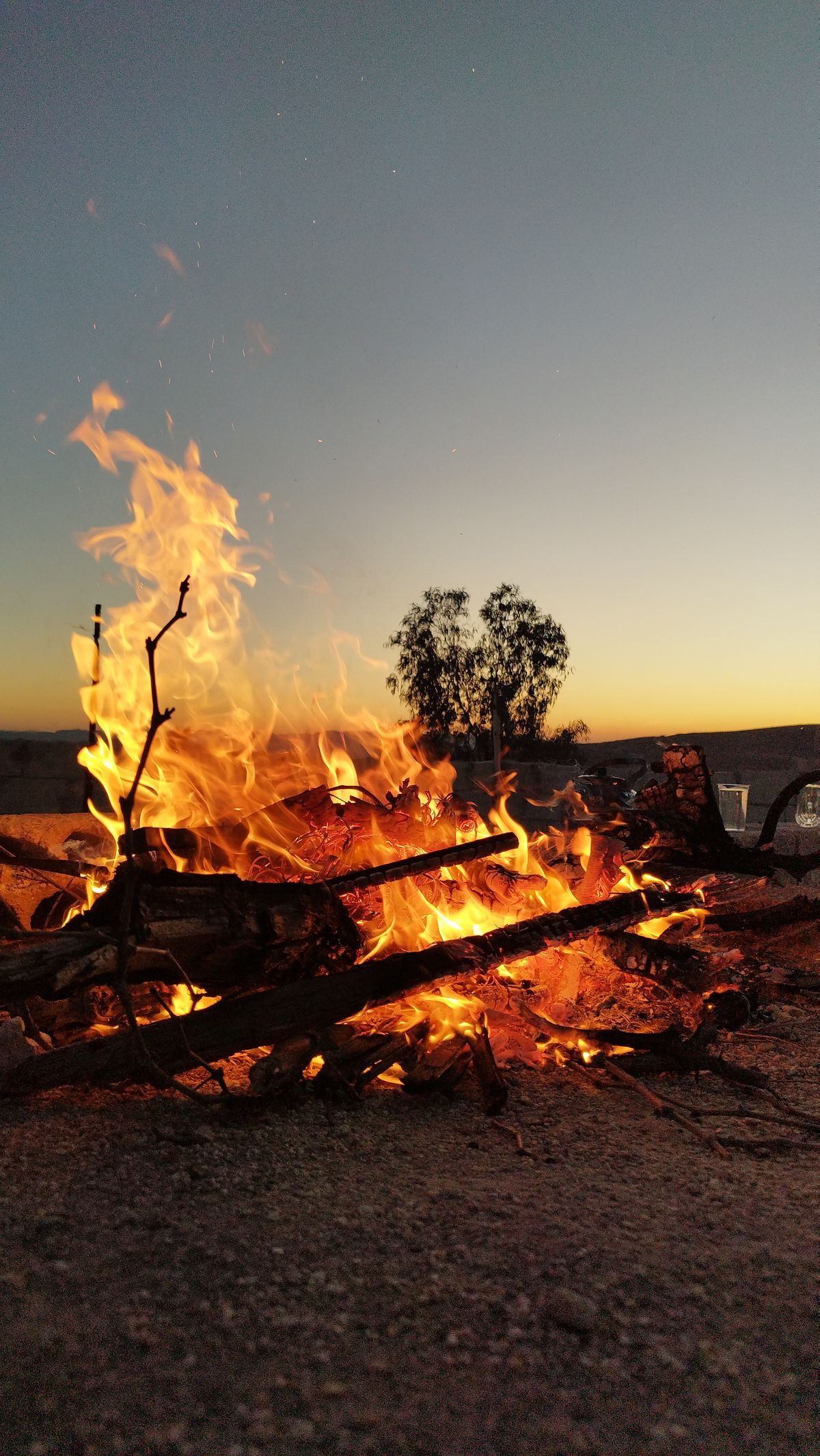 A kettle warming on the campfire as the light returns
