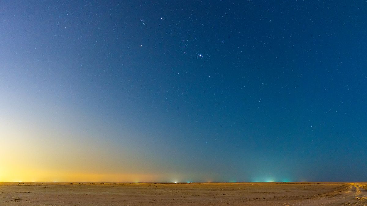 The first stars appearing in the dusk sky over the desert