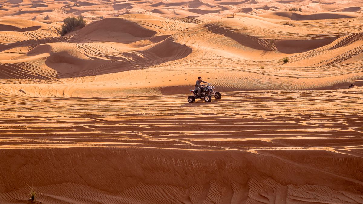 A guest on a quad bike with a guide riding ahead