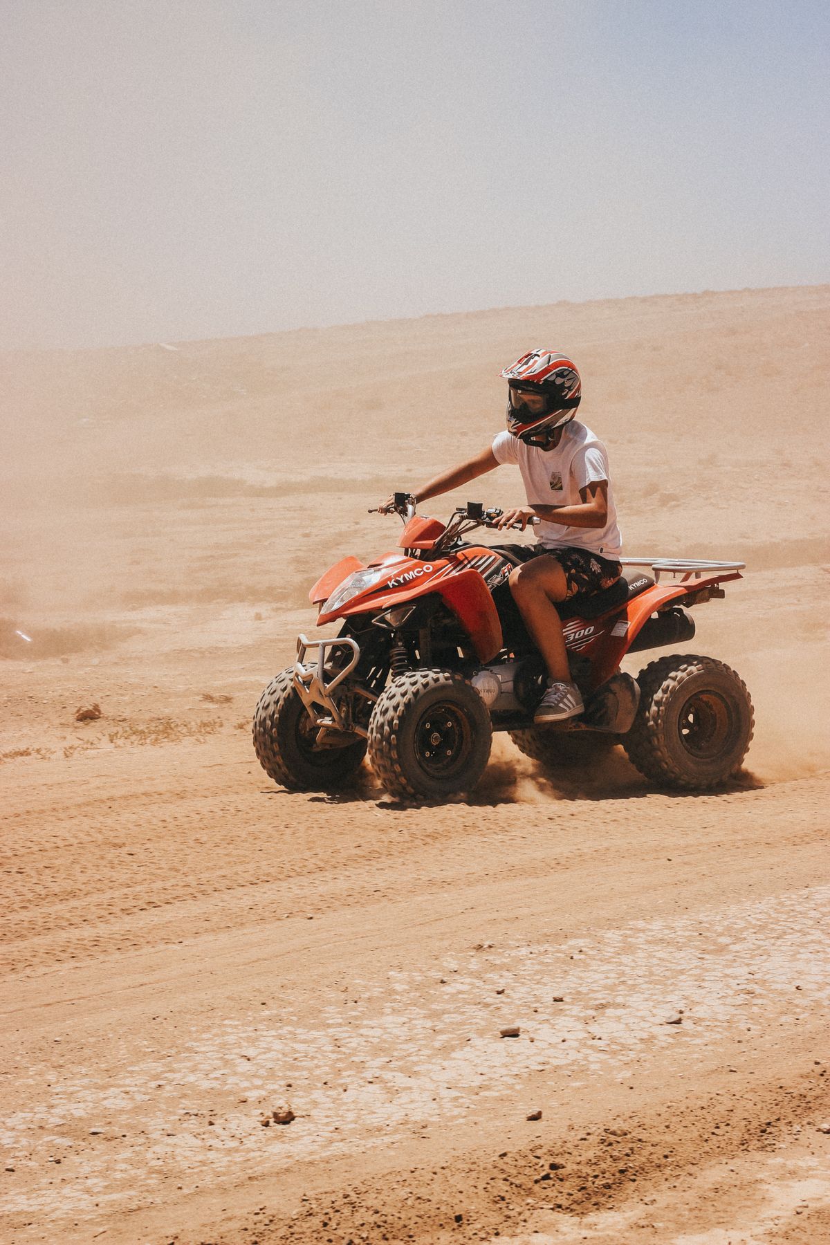A rider following the guide across open sand