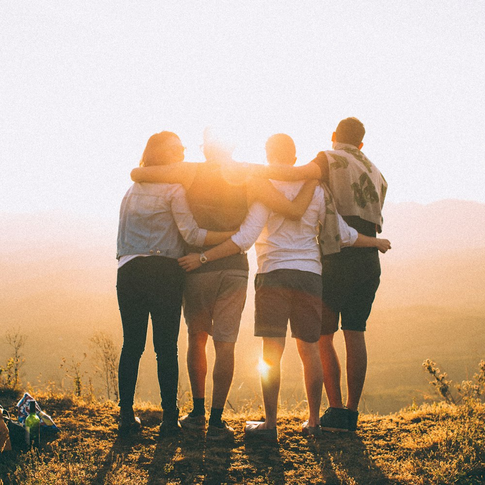 A family standing arm in arm watching the sunset